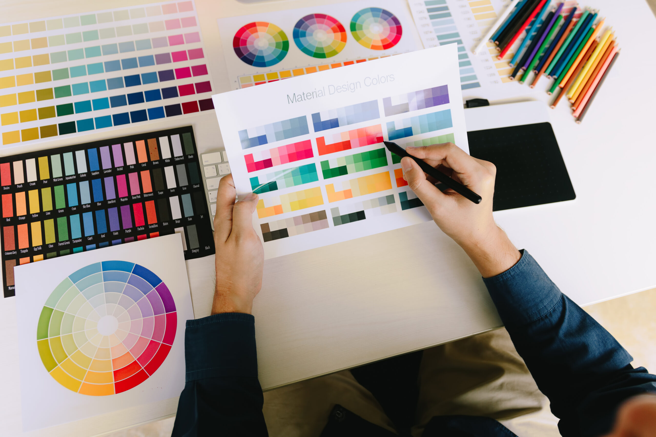 young people holding pen pointing at color sheet in business off